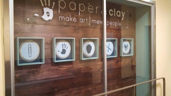 Display case with handprints outside of Paper & Clay.