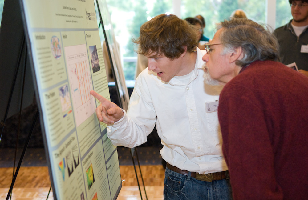 Student and GT faculty member looking closely at a research poster.